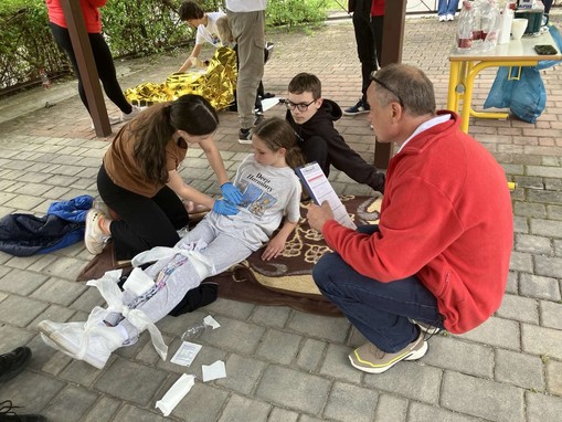 Člana ekipe pri oskrbi namišljene poškodbe.