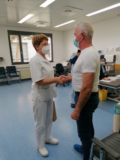 Predstojnica Transfuzijskega centra SB Celje Janja Pajk, dr. med., specialistka transfuziologije, ob plemenitem dejanju, 100-tem darovanju krvi, čestita Alojzu Zagoričniku.